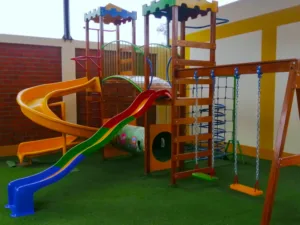 Descubre el Módulo de Madera Edu: con torres tipo Castillo, toboganes, columpio, túnel y trepado. Ideal para el desarrollo físico en parques y jardines.