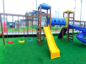 El Módulo de Madera All in One es la solución ideal para cualquier área de recreo que desee ofrecer una experiencia de juego completa y variada para los niños. Con un diseño inteligente y multifuncional, este módulo de 9.10 x 4.50 x 3.30 metros cuenta con una estructura robusta y segura, fabricada con materiales de alta calidad, que asegura la durabilidad y resistencia frente al uso intensivo. Este módulo incluye dos torres con techo, que proporcionan puntos elevados desde donde los niños pueden observar y jugar, conectadas por un túnel clásico que añade un toque de aventura al diseño. Para un descenso lleno de emoción, los pequeños pueden elegir entre un tobogán onda o un tobogán caracol, cada uno ofreciendo una experiencia de deslizamiento única. La escalera de madera y la rampa alpinista fomentan la actividad física y el desarrollo de habilidades motoras, mientras que el pasamanos de madera ofrece apoyo adicional durante los juegos más dinámicos. Además, el módulo cuenta con un columpio de tres asientos, permitiendo que varios niños se diviertan simultáneamente. Este módulo está diseñado para ofrecer un entorno seguro y divertido, ideal para parques, jardines y áreas recreativas. ¡Inspira la imaginación y el movimiento de los niños con el Módulo de Madera All in One y crea momentos inolvidables de juego y aventura!